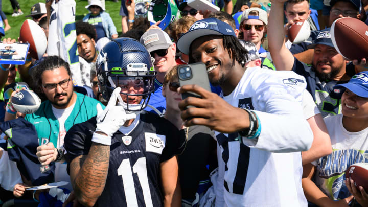 Jul 30, 2023; Renton, WA, USA; Seattle Seahawks wide receiver Jaxon Smith-Njigba (11) and cornerback Riq Woolen (27) take a selfie with fans after practice at the Virginia Mason Athletic Center. Mandatory Credit: Steven Bisig-USA TODAY Sports