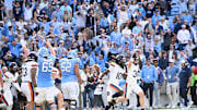 Oct 25, 2025; Chapel Hill, North Carolina, USA; North Carolina Tar Heels and Virginia Cavaliers players react at the end of overtime at Kenan Stadium. Mandatory Credit: Bob Donnan-Imagn Images