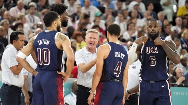 Team USA head coach Steve Kerr talks to Joel Embiid, Jayson Tatum, Stephen Curry, and LeBron James during a game vs. Brazil.