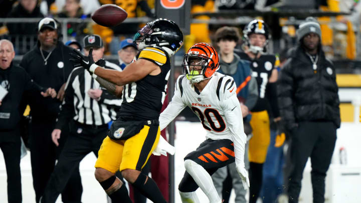 Cincinnati Bengals cornerback DJ Turner II (20) eyes a tipped pass caught by Pittsburgh Steelers running back Jaylen Warren (30) in the second quarter during a Week 16 NFL football game between the Cincinnati Bengals and the Pittsburgh Steelersl, Saturday, Dec. 23, 2023, at Acrisure Stadium in Pittsburgh, Pa.