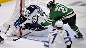 May 17, 2025; Dallas, Texas, USA; Winnipeg Jets goaltender Connor Hellebuyck (37) stops a shot by Dallas Stars left wing Jason Robertson (21) during the first period in game six of the second round of the 2025 Stanley Cup Playoffs at American Airlines Center. Mandatory Credit: Jerome Miron-Imagn Images
