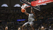 Mar 8, 2025; Morgantown, West Virginia, USA; West Virginia Mountaineers guard Toby Okani (5) dunks the ball during the first half against the UCF Knights at WVU Coliseum. Mandatory Credit: Ben Queen-Imagn Images
