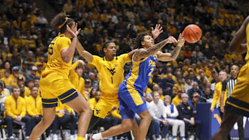 Nov 13, 2025; Morgantown, West Virginia, USA; Pittsburgh Panthers forward Cameron Corhen (2) passes between pressure from West Virginia Mountaineers center Harlan Obioha (55) and West Virginia Mountaineers guard Jasper Floyd (1) during the first half at WVU Coliseum. Mandatory Credit: Ben Queen-Imagn Images