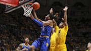 Nov 13, 2025; Morgantown, West Virginia, USA; Pittsburgh Panthers guard Omari Witherspoon (8) drives and shoots against West Virginia Mountaineers guard Jasper Floyd (1) during the first half at WVU Coliseum. Mandatory Credit: Ben Queen-Imagn Images