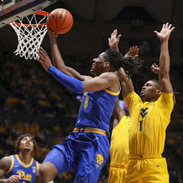 Nov 13, 2025; Morgantown, West Virginia, USA; Pittsburgh Panthers guard Omari Witherspoon (8) drives and shoots against West Virginia Mountaineers guard Jasper Floyd (1) during the first half at WVU Coliseum. Mandatory Credit: Ben Queen-Imagn Images