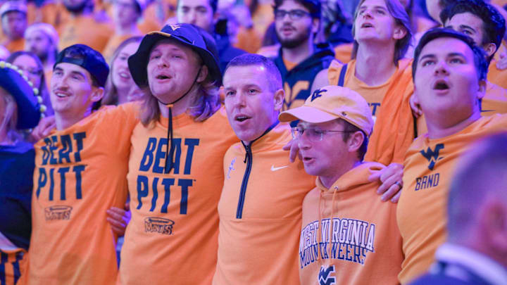 Nov 13, 2025; Morgantown, West Virginia, USA; West Virginia Mountaineers head coach Ross Hodge sings “Country Roads” with students after defeating the Pittsburgh Panthers at WVU Coliseum. Mandatory Credit: Ben Queen-Imagn Images