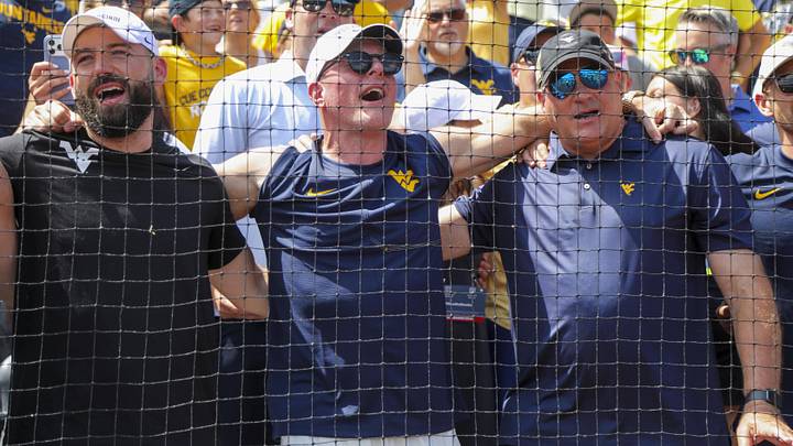 Jun 5, 2026; Morgantown, WV, USA; Pat McAfee and West Virginia head football coach Rich Rodriguez sing “Country Roads” after defeating the Cal Poly Mustangs at Kendrick Family Ballpark. Mandatory Credit: Ben Queen-Imagn Images