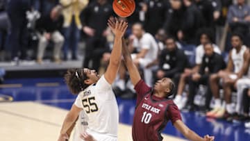 Dec 9, 2025; Morgantown, West Virginia, USA; West Virginia Mountaineers center Harlan Obioha (55) and Little Rock Trojans forward Caleb Pennyfeather (10) jump for the tip off during the first half at Hope Coliseum. Mandatory Credit: Ben Queen-Imagn Images