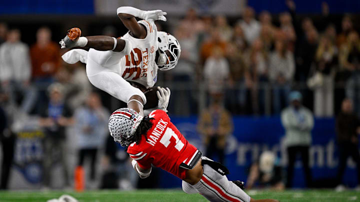 Jan 10, 2025; Arlington, TX, USA; Texas Longhorns running back Quintrevion Wisner (26) and Ohio State Buckeyes cornerback Jordan Hancock (7) in action during the game between the Texas Longhorns and the Ohio State Buckeyes Jan 10, 2025; Arlington, TX, USA; Texas Longhorns running back Quintrevion Wisner (26) and Ohio State Buckeyes cornerback Jordan Hancock (7) in action during the game between the Texas Longhorns and the Ohio State Buckeyes