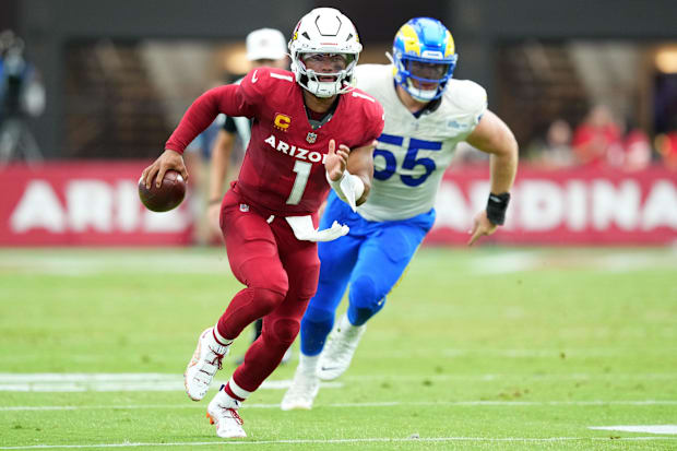 Arizona Cardinals quarterback Kyler Murray runs from a Los Angeles Rams defender.