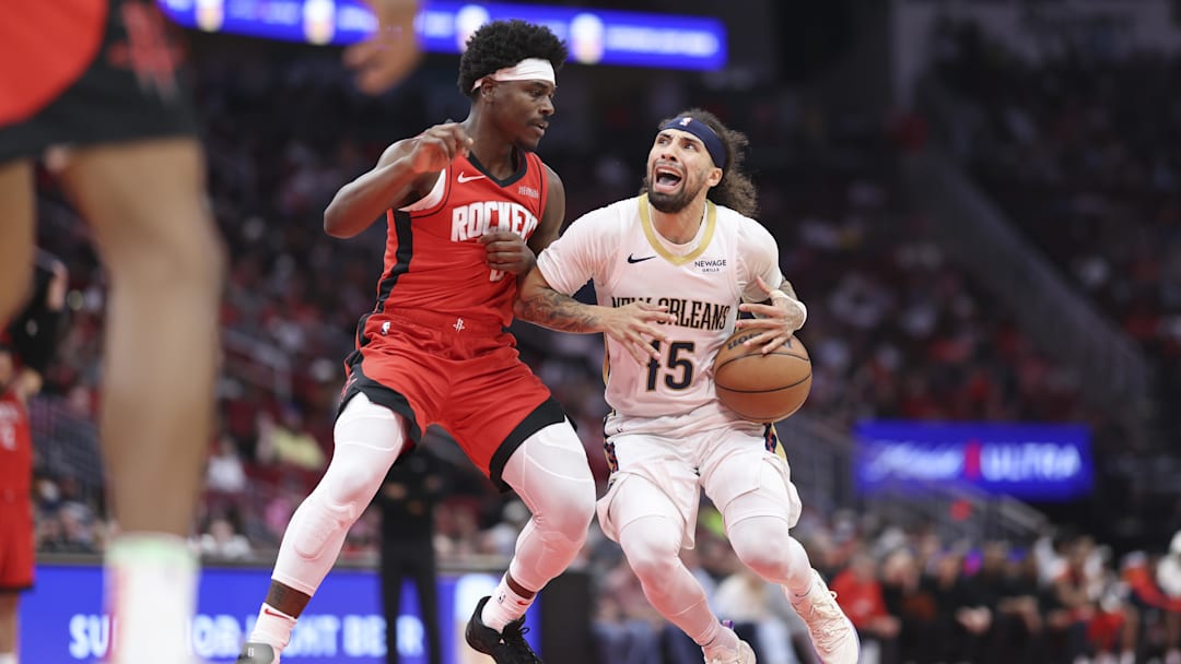Mar 8, 2025; Houston, Texas, USA;  New Orleans Pelicans guard Jose Alvarado (15) controls the ball as Houston Rockets guard Aaron Holiday (0) defends during the game at Toyota Center. Mandatory Credit: Troy Taormina-Imagn Images