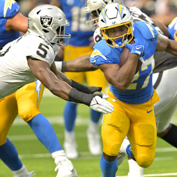 Sep 8, 2024; Inglewood, California, USA; Los Angeles Chargers running back J.K. Dobbins (27) breaks away from Las Vegas Raiders linebacker Divine Deablo (5) and runs for a touchdown in the second half at SoFi Stadium. Mandatory Credit: Jayne Kamin-Oncea-Imagn Images