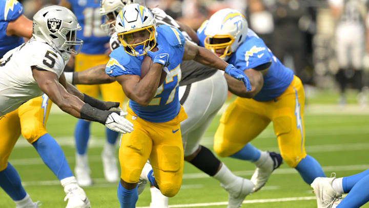 Sep 8, 2024; Inglewood, California, USA; Los Angeles Chargers running back J.K. Dobbins (27) breaks away from Las Vegas Raiders linebacker Divine Deablo (5) and runs for a touchdown in the second half at SoFi Stadium. Mandatory Credit: Jayne Kamin-Oncea-Imagn Images