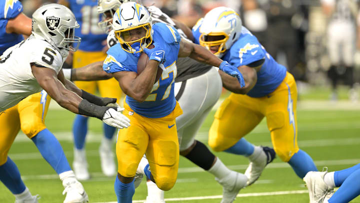 Sep 8, 2024; Inglewood, California, USA; Los Angeles Chargers running back J.K. Dobbins (27) breaks away from Las Vegas Raiders linebacker Divine Deablo (5) and runs for a touchdown in the second half at SoFi Stadium. Mandatory Credit: Jayne Kamin-Oncea-Imagn Images