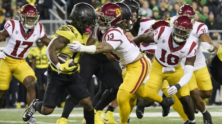 Nov 11, 2023; Eugene, Oregon, USA; USC Trojans linebacker Mason Cobb (13) tackles Oregon Ducks running back Bucky Irving (0) at Autzen Stadium. Mandatory Credit: Troy Wayrynen-USA TODAY Sports