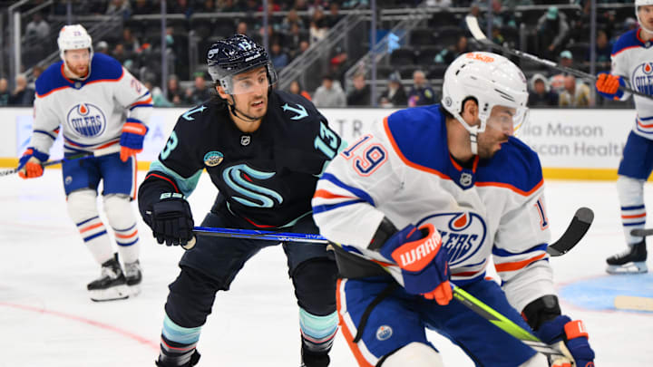 Seattle Kraken left wing Brandon Tanev (13) plays defense on Edmonton Oilers center Adam Henrique (19)