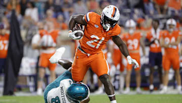 Aug 30, 2025; Charlottesville, Virginia, USA; Virginia Cavaliers running back Harrison Waylee (21) carries the ball as Coastal Carolina Chanticleers cornerback Myles Mooyoung (8) defends during the second half at Scott Stadium. Mandatory Credit: Amber Searls-Imagn Images