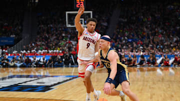 Mar 21, 2025; Seattle, WA, USA; Akron Zips guard Isaiah Gray (13) dribbles the ball past Arizona Wildcats forward Carter Bryant (9) during the second half in the first round of the NCAA Tournament at Climate Pledge Arena. Mandatory Credit: Steven Bisig-Imagn Images