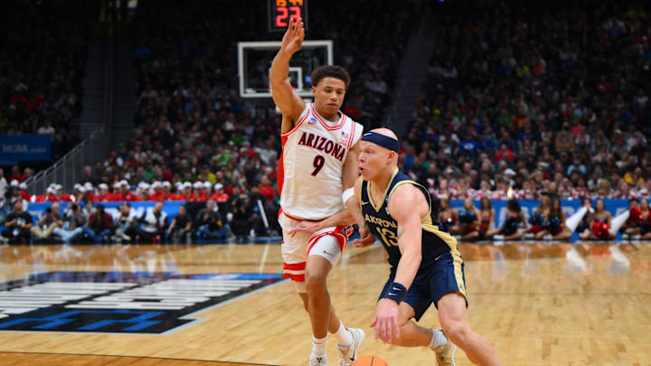 Mar 21, 2025; Seattle, WA, USA; Akron Zips guard Isaiah Gray (13) dribbles the ball past Arizona Wildcats forward Carter Bryant (9) during the second half in the first round of the NCAA Tournament at Climate Pledge Arena. Mandatory Credit: Steven Bisig-Imagn Images