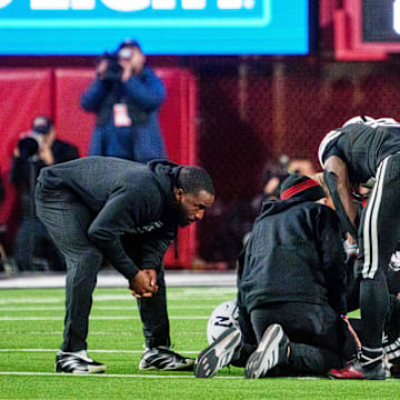 Matt Rhule and running back Emmett Johnson gather around quarterback Dylan Raiola after he was injured during the third quarter against the Southern California Trojans at Memorial Stadium. 