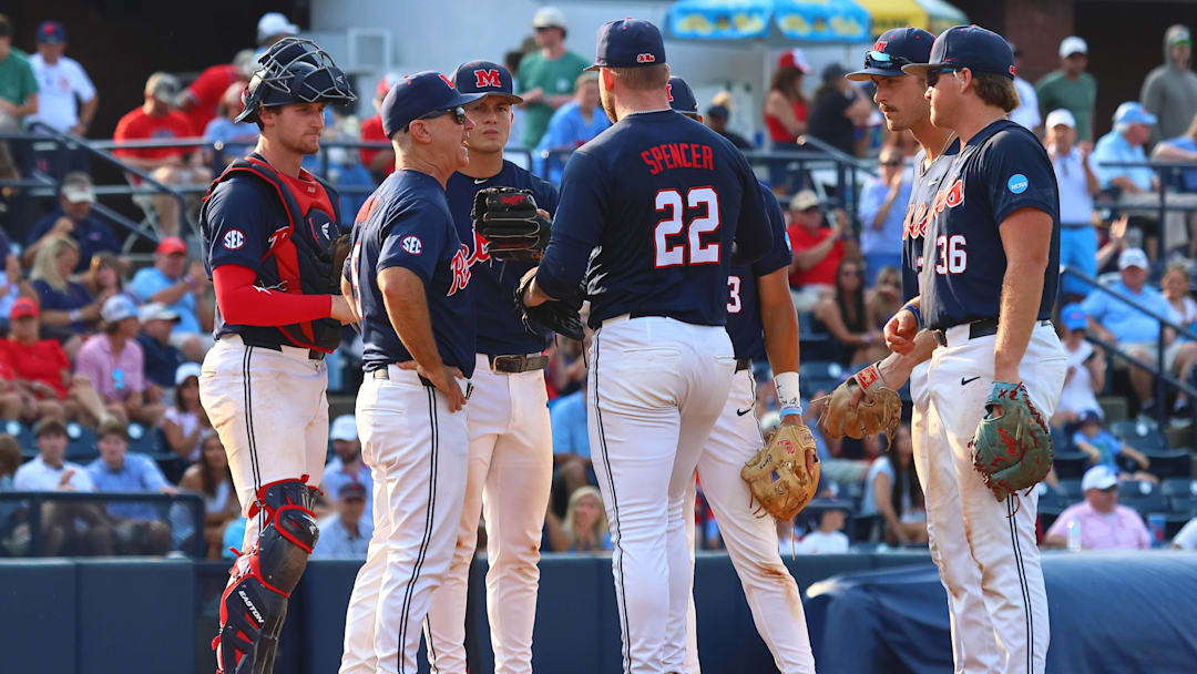 Jun 1, 2025; Oxford, MS, USA; Mississippi Rebels head coach Mike Bianco (left) makes a pitching change to pitcher Connor Spencer (22) during the ninth inning against the Georgia Tech Yellowjackets. Mandatory Credit: Petre Thomas-Imagn Images
