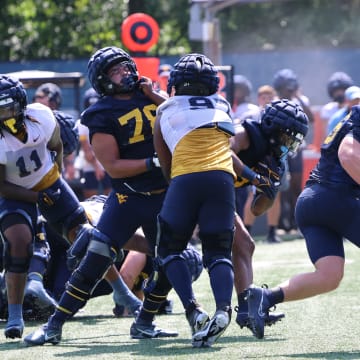 West Virginia University running back CJ Donaldson busts through the middle of the line of scrimmage during fall camp (2024).
