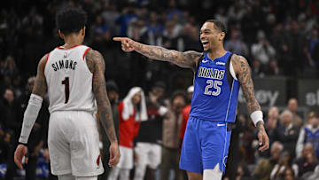 Jan 9, 2025; Dallas, Texas, USA; Dallas Mavericks forward P.J. Washington (25) laughs and points to his teammates as Portland Trail Blazers guard Anfernee Simons (1) walks back up the court during the second half at the American Airlines Center. Mandatory Credit: Jerome Miron-Imagn Images