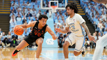Mar 1, 2025; Chapel Hill, North Carolina, USA;  Miami (Fl) Hurricanes guard Divine Ugochukwu (99) with the ball as North Carolina Tar Heels guard Elliot Cadeau (3) defends in the first half at Dean E. Smith Center. Mandatory Credit: Bob Donnan-Imagn Images
