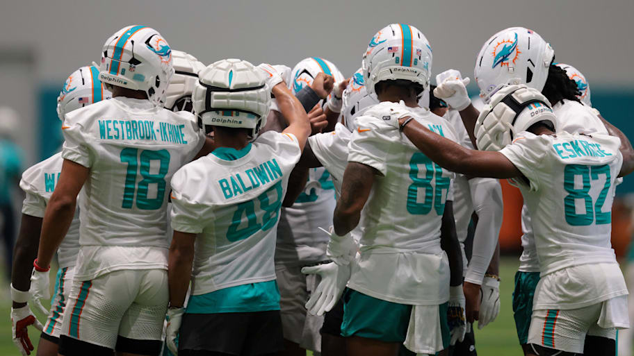 Miami Dolphins players huddle during training camp at Baptist Health Training Complex. | Sam Navarro-Imagn Images