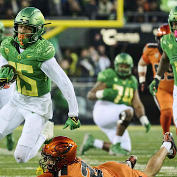 Nov 24, 2023; Eugene, Oregon, USA; Oregon Ducks wide receiver Tez Johnson (15) catches a pass for a first down during the second half as he breaks away from Oregon State Beavers defensive back Jack Kane (24) and defensive back Kitan Oladapo (28) at Autzen Stadium. Mandatory Credit: Troy Wayrynen-Imagn Images