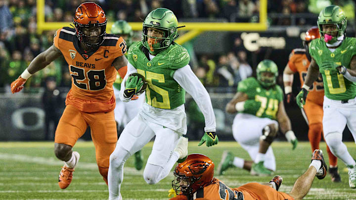 Nov 24, 2023; Eugene, Oregon, USA; Oregon Ducks wide receiver Tez Johnson (15) catches a pass for a first down during the second half as he breaks away from Oregon State Beavers defensive back Jack Kane (24) and defensive back Kitan Oladapo (28) at Autzen Stadium. Mandatory Credit: Troy Wayrynen-Imagn Images