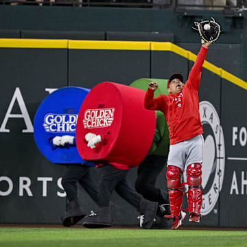 Sep 5, 2024; Arlington, Texas, USA; Los Angeles Angels bullpen catcher Jason Brown (93) catches a ball in the outfield as the Texas Rangers dots race runs behind him during the game at Globe Life Field. Mandatory Credit: Jerome Miron-Imagn Images