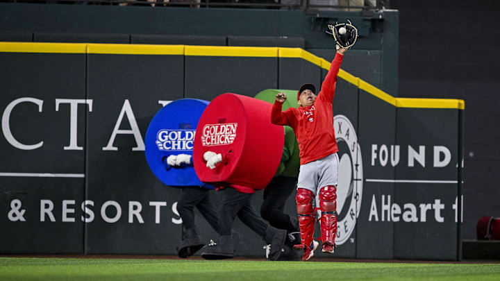 Sep 5, 2024; Arlington, Texas, USA; Los Angeles Angels bullpen catcher Jason Brown (93) catches a ball in the outfield as the Texas Rangers dots race runs behind him during the game at Globe Life Field. Mandatory Credit: Jerome Miron-Imagn Images