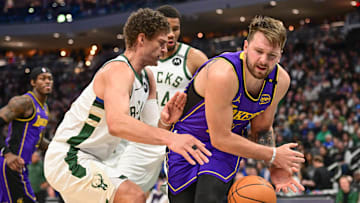 Mar 13, 2025; Milwaukee, Wisconsin, USA; Milwaukee Bucks center Brook Lopez (11) defends Los Angeles Lakers guard Luka Doncic (77) in the third quarter at Fiserv Forum. Mandatory Credit: Benny Sieu-Imagn Images
