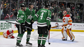 Dec 8, 2024; Dallas, Texas, USA; Dallas Stars center Colin Blackwell (15) and left wing Jason Robertson (21) and defenseman Miro Heiskanen (4) celebrates a goal scored by Robertson against Calgary Flames goaltender Dustin Wolf (32) during the second period at the American Airlines Center. Mandatory Credit: Jerome Miron-Imagn Images
