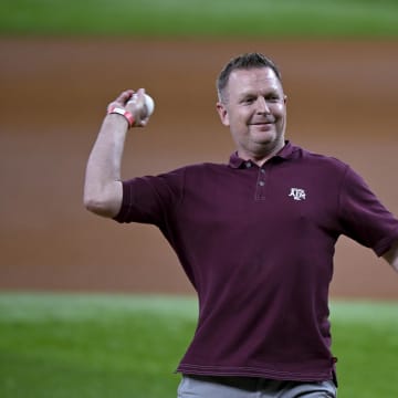 Aug 4, 2023; Arlington, Texas, USA; Texas A&M Aggies baseball head coach Jim Schlossnagle throws out the first pitch before the game between the Texas Rangers and the Miami Marlins at Globe Life Field. Mandatory Credit: Jerome Miron-USA TODAY Sports
