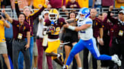 BYU quarterback Jake Retzlaff (12) tackles Arizona State defensive back Javan Robinson (12) as he returns an interception during the second half of the Sun Devils' 28-23 win.