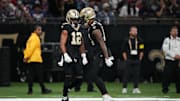 Oct 12, 2025; New Orleans, Louisiana, USA; New Orleans Saints wide receiver Chris Olave (12) and wide receiver Devaughn Vele (14) react during the first quarter against the New England Patriots at Caesars Superdome. Mandatory Credit: Matthew Hinton-Imagn Images
