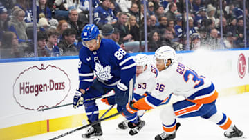 Dec 31, 2024; Toronto, Ontario, CAN; Toronto Maple Leafs right wing William Nylander (88) battles for the puck with New York Islanders defenseman Isaiah George (36) during the third period at the Scotiabank Arena. Mandatory Credit: Nick Turchiaro-Imagn Images
