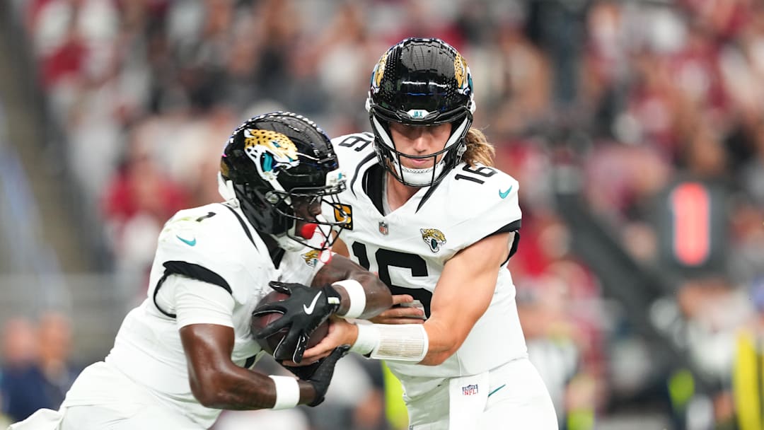 Nov 23, 2025; Glendale, Arizona, USA; Jacksonville Jaguars quarterback Trevor Lawrence (16) hands the ball off to Jacksonville Jaguars running back Travis Etienne Jr. (1) during the first quarter against the Arizona Cardinals at State Farm Stadium. 