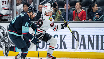 Nov 14, 2024; Seattle, Washington, USA;  Chicago Blackhawks forward Connor Bedard (98) skates against Seattle Kraken defenseman Adam Larsson (6) during the second period at Climate Pledge Arena. Mandatory Credit: Stephen Brashear-Imagn Images