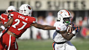 Oct 4, 2025; Louisville, Kentucky, USA; Virginia Cavaliers running back J'Mari Taylor (3) runs the ball past the reach of Louisville Cardinals defensive back JoJo Evans Jr. (27) during the second quarter at L&N Federal Credit Union Stadium. Mandatory Credit: Jamie Rhodes-Imagn Images