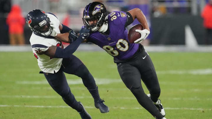 Baltimore Ravens tight end Isaiah Likely (80) runs the ball against Houston Texans cornerback Desmond King II (25) during the third quarter of a 2024 AFC divisional round game at M&T Bank Stadium. 