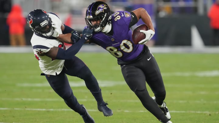 Baltimore Ravens tight end Isaiah Likely (80) runs the ball against Houston Texans cornerback Desmond King II (25) during the third quarter of a 2024 AFC divisional round game at M&T Bank Stadium. 