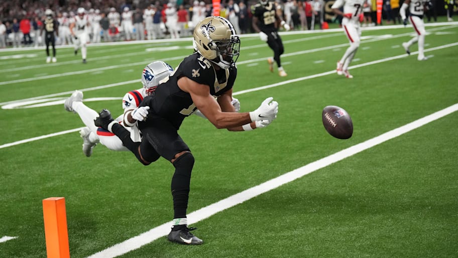 Saints wide receiver Chris Olave (12) misses a touchdown pass under pressure from Patriots cornerback Marcus Jones