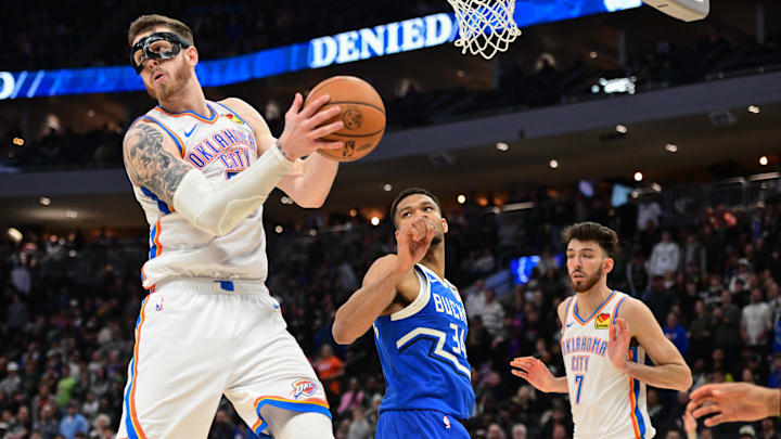 Mar 16, 2025; Milwaukee, Wisconsin, USA; Oklahoma City Thunder center Isaiah Hartenstein (55) grabs a rebound against Milwaukee Bucks forward Giannis Antetokounmpo (34) in the fourth quarter at Fiserv Forum. Mandatory Credit: Benny Sieu-Imagn Images