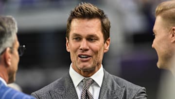 Dec 29, 2024; Minneapolis, Minnesota, USA;  FOX broadcaster and former NFL quarterback Tom Brady looks on before the game between the Minnesota Vikings and the Green Bay Packers at U.S. Bank Stadium. Mandatory Credit: Jeffrey Becker-Imagn Images