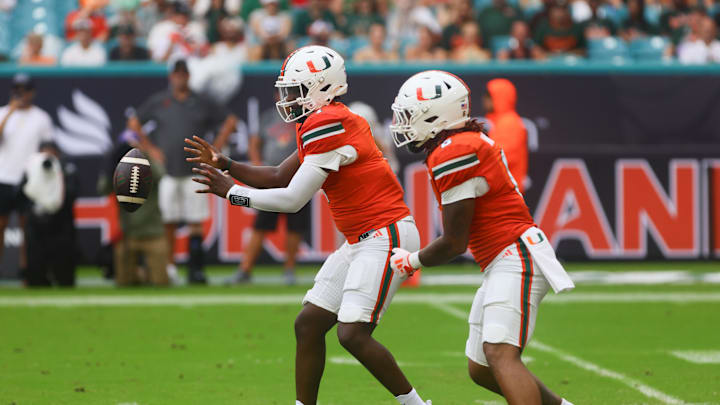 Sep 14, 2024; Miami Gardens, Florida, USA; Miami Hurricanes quarterback Cam Ward (1) catches the snap against the Ball State Cardinals during the first quarter at Hard Rock Stadium. Mandatory Credit: Sam Navarro-Imagn Images