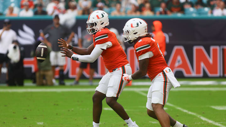 Sep 14, 2024; Miami Gardens, Florida, USA; Miami Hurricanes quarterback Cam Ward (1) catches the snap against the Ball State Cardinals during the first quarter at Hard Rock Stadium. Mandatory Credit: Sam Navarro-Imagn Images