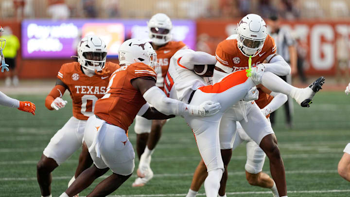 Sep 20, 2025; Austin, Texas, USA; Texas Longhorns defensive back Malik Muhammad (5) and defensive lineman Colin Simmons (1) tackle Sam Houston Bearkats quarterback Grant Gunnell (10) during the first half at Darrell K Royal-Texas Memorial Stadium. Mandatory Credit: Scott Wachter-Imagn Images
